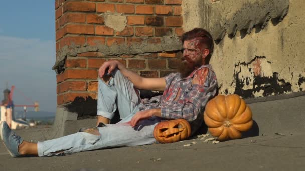 Dia dos mortos, homem com abóboras a celebrar o Dia das Bruxas. Férias de outono, monstro gosta do sol, conceito de horror. Homem de sangue com o rosto ferido partido e Jack — Vídeo de Stock