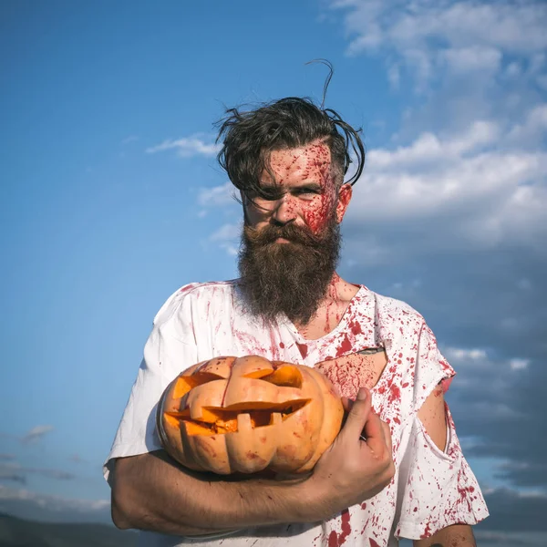 Halloween uomo che tiene la zucca sul cielo blu — Foto Stock