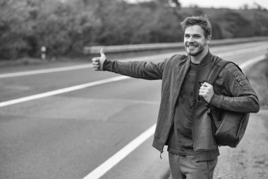Genç adam otostop çekiyor.
