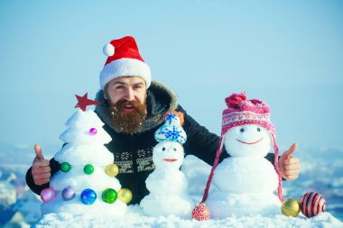 Şapkalar ve kar kardan adam xmas ağacı üzerinde mavi gökyüzü