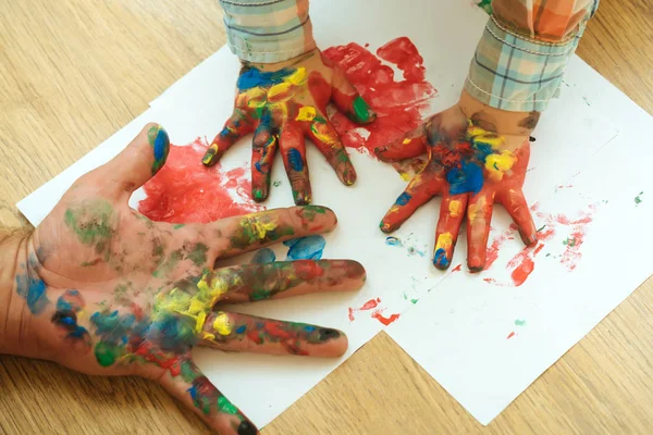 Elleri ve parmakları ile çok renkli boyalar beyaz kağıt üzerine çizim