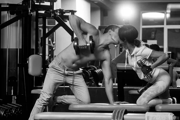 Musculoso homem e menina no ginásio com halteres — Fotografia de Stock