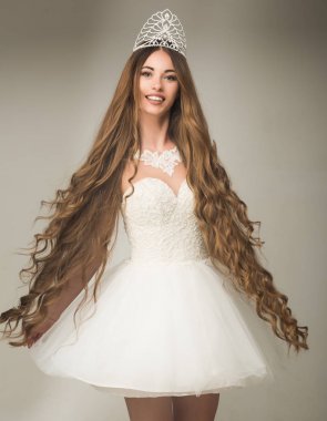 Kızın şık makyajı ve gri arka planda sağlıklı saçları var..