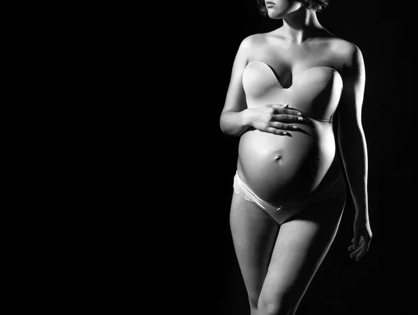 Velmi těhotná žena s kulatým břichem izolované na černém pozadí — Stock fotografie