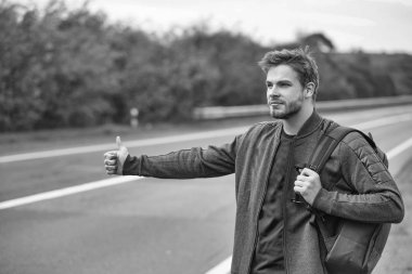 Genç adam otostop çekiyor.