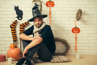 Hediye kutusu ve bardak katta oturan Cadılar Bayramı adam.