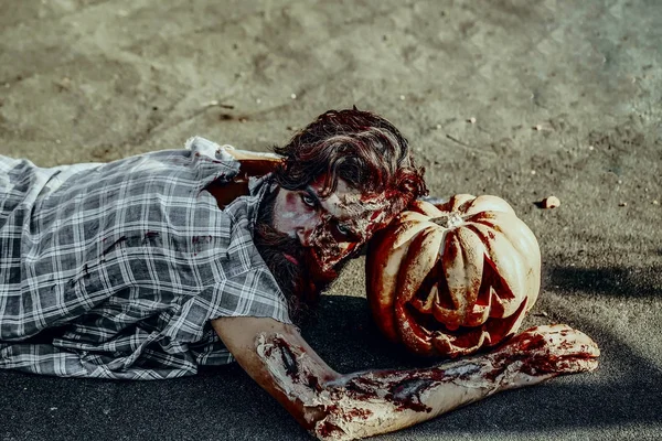 Halloween man liegen met pompoen — Stockfoto