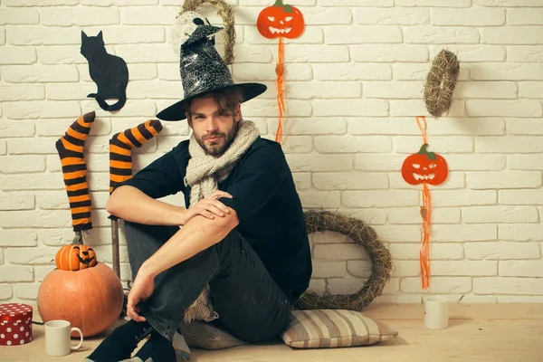 Hediye kutusu ve bardak katta oturan Cadılar Bayramı adam.