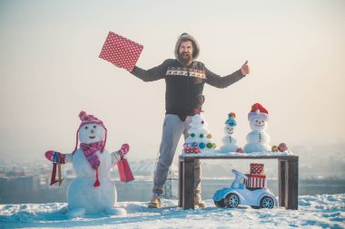 Kardan adam alışveriş torbaları üzerinde beyaz sky ile