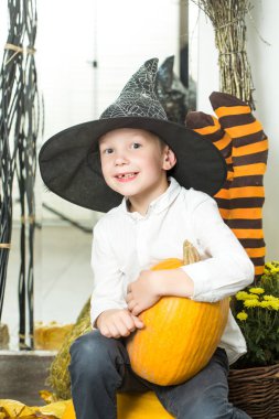 Cadılar Bayramı çocuk cadı şapka kabak portakal ile.