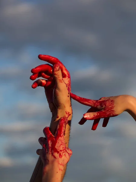 Кровавые руки зомби с красной кровью на голубом небе — стоковое фото