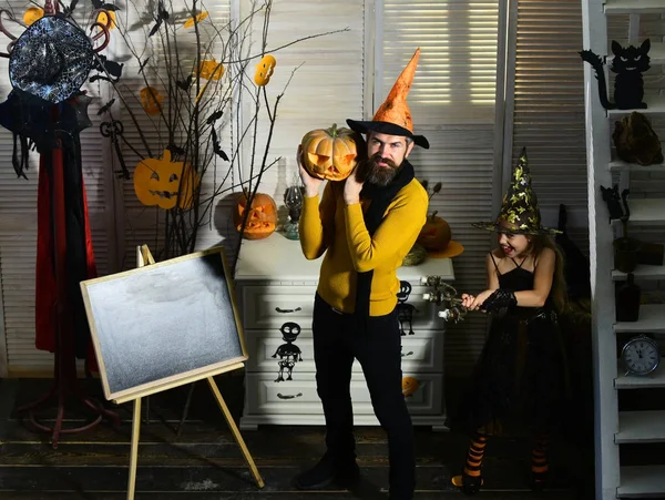 Girl witch and bearded wizard hold pumpkin and candlestick — Stock Photo, Image