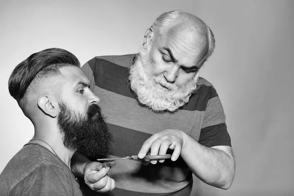 Cabeleireiro velho e homem barbudo jovem — Fotografia de Stock