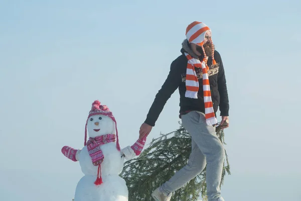 Hipster kerstboom op winterdag te slepen — Stockfoto