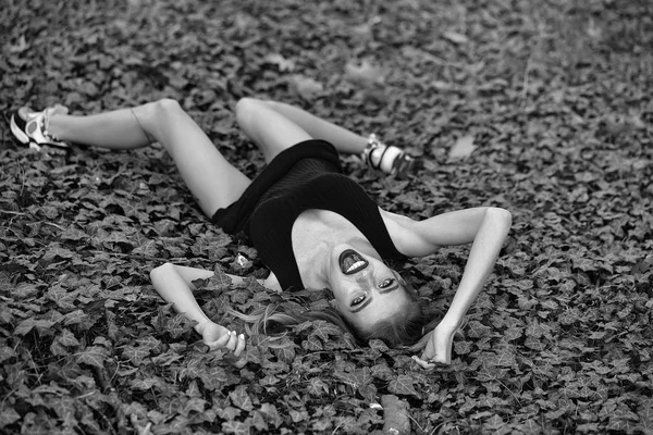 緑の葉の上に横たわる少女の笑みを浮かべてください。 — ストック写真