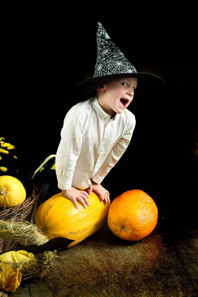 Enfant Halloween avec citrouille orange en chapeau de sorcière . — Photo