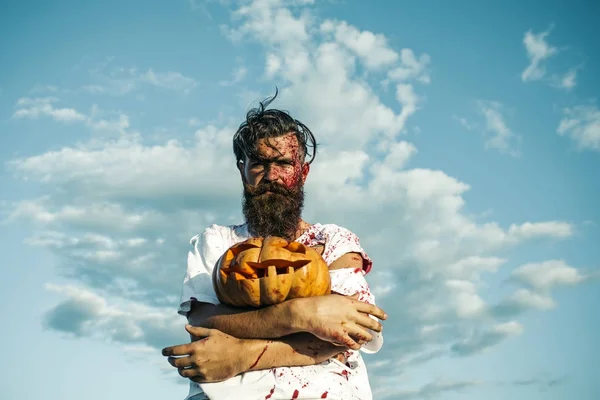 Halloween hipster uomo tenendo zucca sul cielo blu — Foto Stock