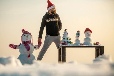 Adam ve kardan adam holding eller üzerinde beyaz gökyüzü