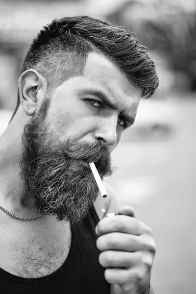Bearded man lights cigarette — Stock Photo, Image