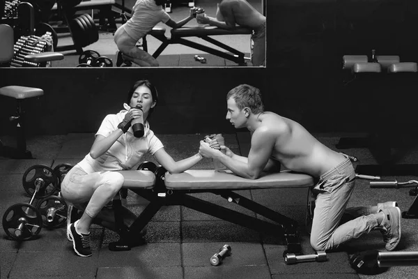 Muskularny mężczyzna siłowanie się na rękę i dziewczyna w siłowni — Zdjęcie stockowe