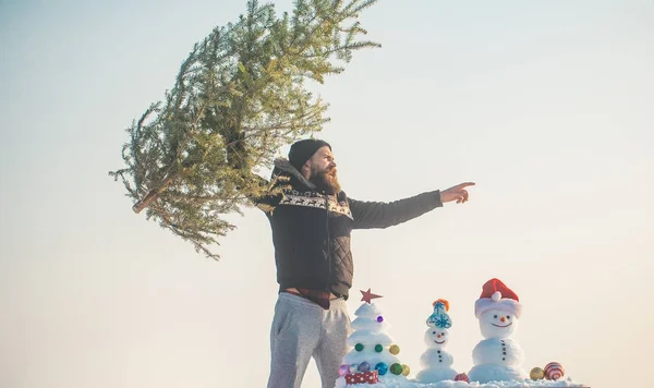 Człowiek, podnoszenie Boże Narodzenie drzewo i wskazując palcem — Zdjęcie stockowe