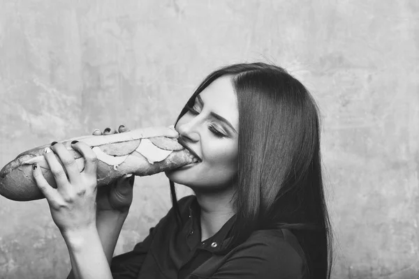 Σέξι λίγο μελαχρινή γυναίκα χαμογελαστά τρώει μεγάλο σάντουιτς ή μπιφτέκι — Φωτογραφία Αρχείου