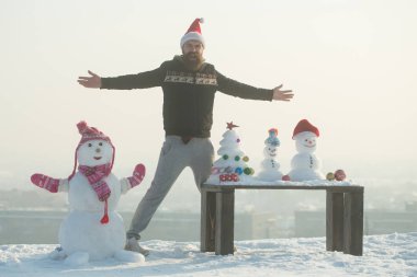 Açık beyaz gökyüzü ellerde adam ve kardan adam ile