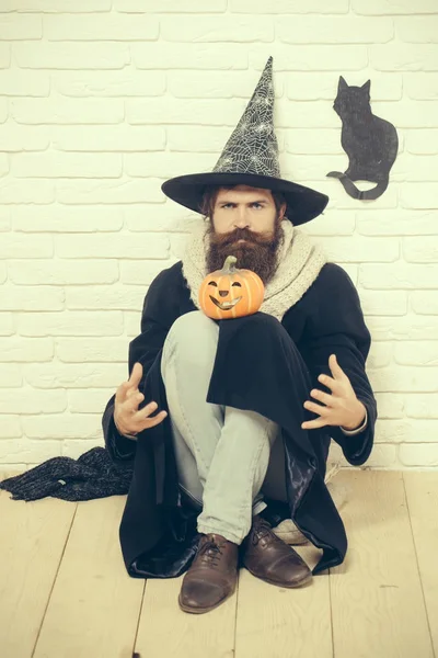 Halloween uomo in cappello da strega seduto sul pavimento — Foto Stock