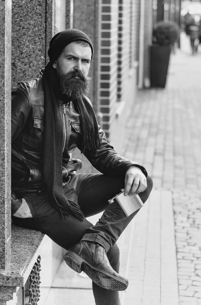 Serious bearded man hipster with wine bottle in leather jacket — Stock Photo, Image