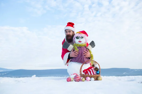 Man in KERSTMUTS knuffelen sneeuwpop — Stockfoto