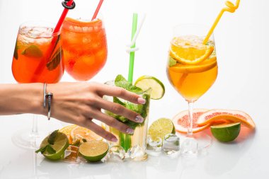 İçki ve yiyecek. Meyve dilim ve kokteyl cam bar. Alkollü içecek ve meyve kadın el ile restoranda. Parti ve yaz tatil. Mojito beyaz zemin üzerine izole kokteyl.