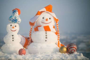 Gülen yüzler üzerinde mavi gökyüzü ile iki kar heykeller