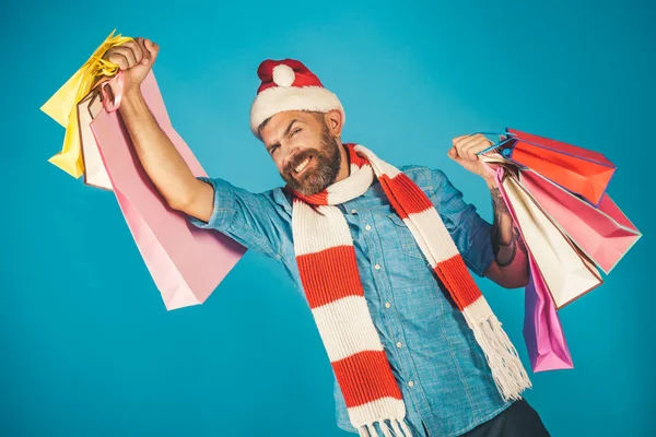 サンタの帽子とマフラーでクリスマス男の買い物客の幸せな笑顔します。 — ストック写真