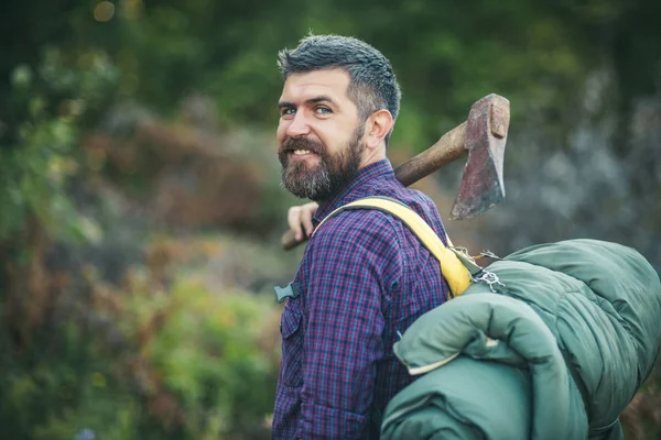 Mannen lumberjack glada leende med yxa och ryggsäck — Stockfoto