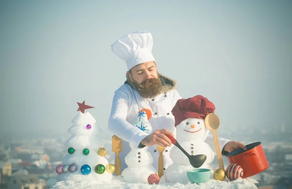 Man in de hoed van de chef-kok ladling soep op winterdag — Stockfoto