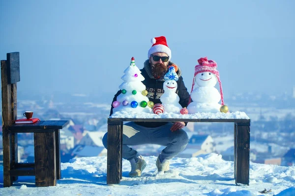 Hipster zittend met sneeuwmannen en sneeuw kerstboom op tafel — Stockfoto