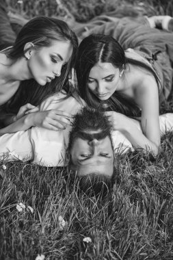 Sakallı adam ve iki kadınla çimenlerin üzerinde