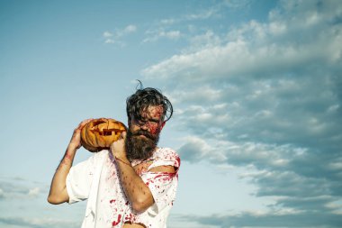 Cadılar Bayramı hipster kabak bulutlu mavi gökyüzü üzerinde tutan