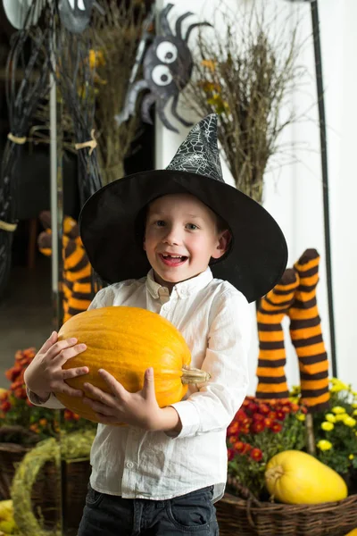 Halloween criança em chapéu de bruxa com abóbora amarela — Fotografia de Stock