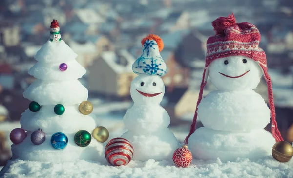 Muñecos de nieve con caras sonrientes en sombreros en el día de invierno — Foto de Stock