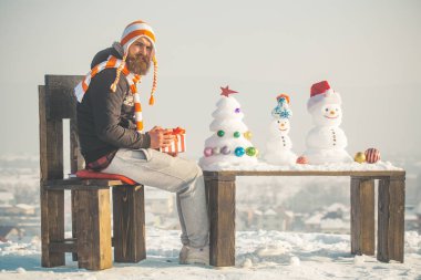 Sandalyede oturan şapkalı adam