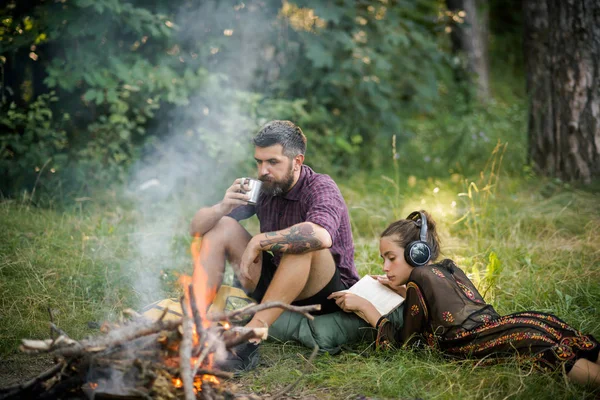 旅行者のカップルが森でたき火でリラックスします。 — ストック写真