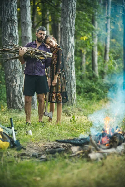 Женщина обнимает мужчину лесорубом с топором и кучей дров — стоковое фото