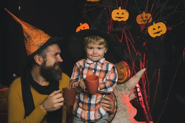 Halloween Father and small son drink from tea or milk cup.