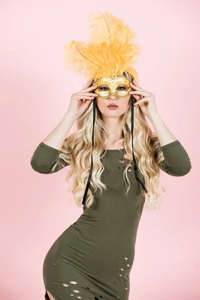 Žena má dlouhé blond vlasy v karnevalové masce. — Stock fotografie