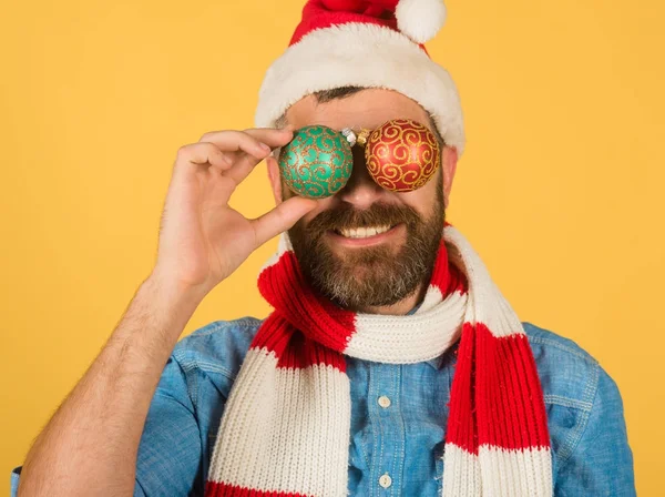 Noël homme couvrir les yeux avec des boules de Noël sur fond jaune — Photo