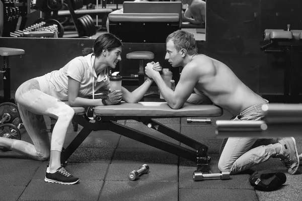 Muskularny mężczyzna siłowanie się na rękę i dziewczyna w siłowni — Zdjęcie stockowe