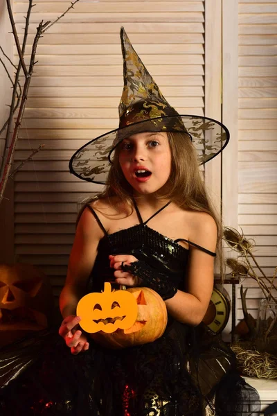Kleine Hexe mit Halloween-Dekor. Mädchen mit überraschtem Gesicht — Stockfoto