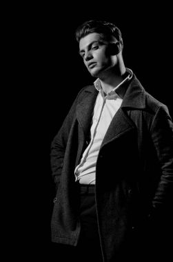 Yakışıklı adam beyaz gömlek ve karanlık kat poz