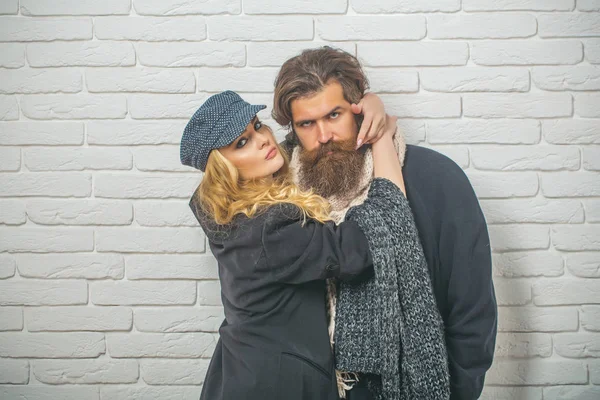 Boyfriend and girlfriend on brick wall background.